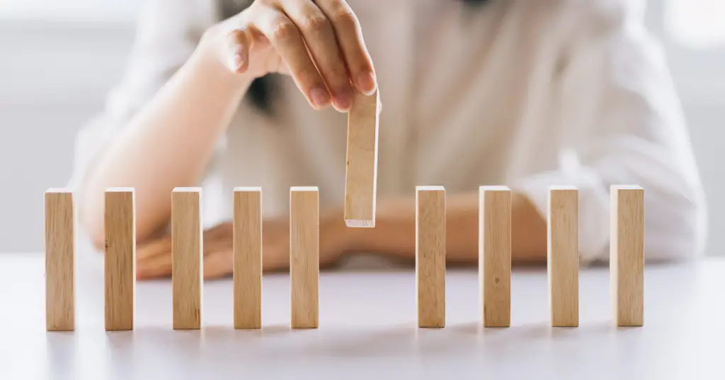 A hand aligning vertical blocks