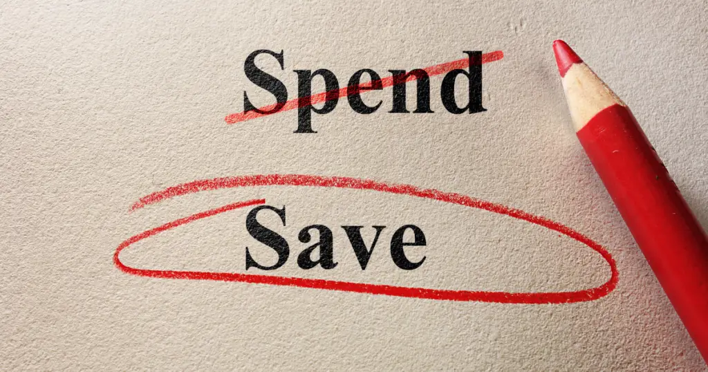 Red colored pencil on a paper that has "spend" crossed out and a circle around the word "Save"