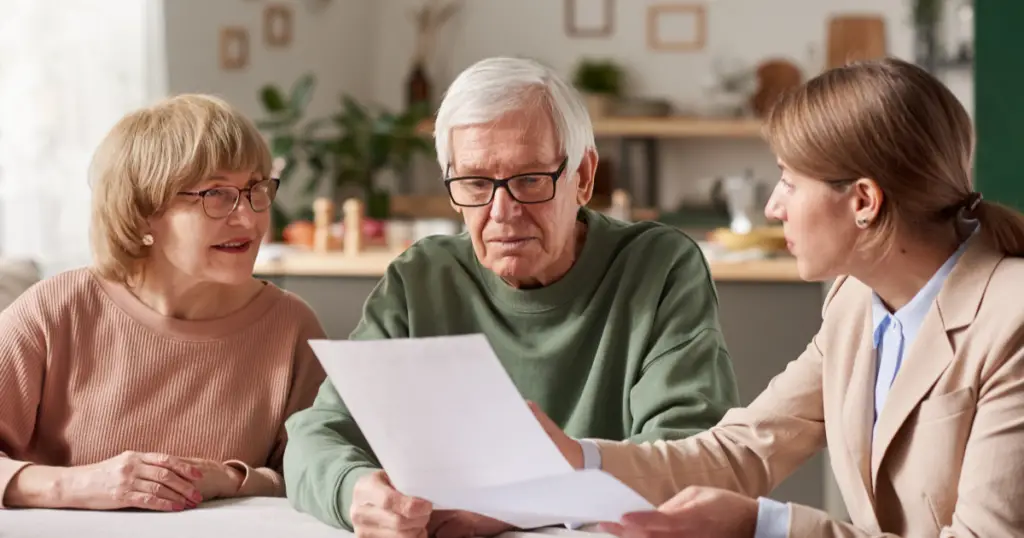 Three people in a home looking at a white piece of paper