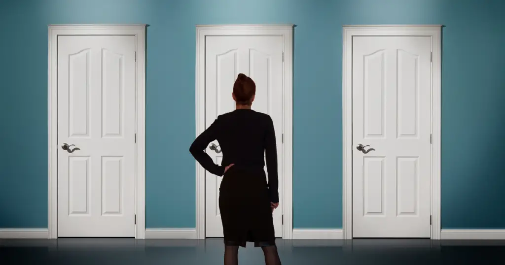 Back of a woman staring at three closed doors