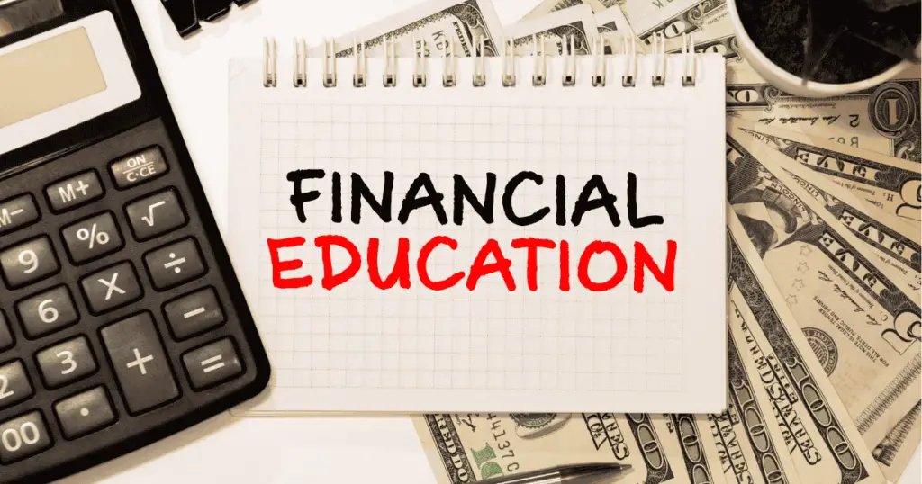 Financial education written in a notebook next to a calculator and cash